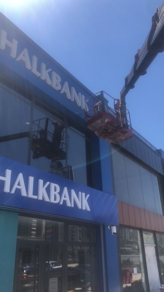 Sepetli vinç sepetinden Keçiören Ovacık Halkbank Şubesi dış cephe cam temizliği — uzman aktif çalışma sırasında